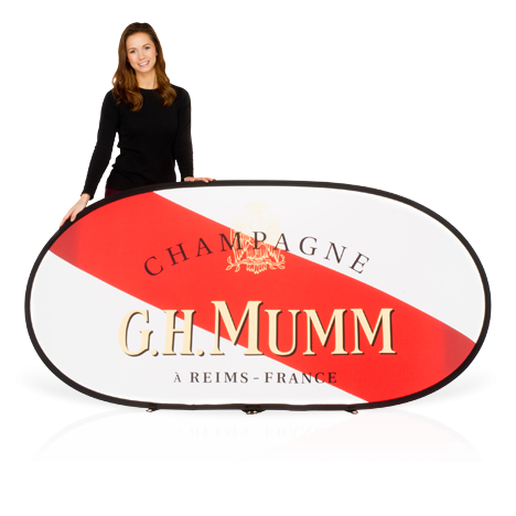 Female model wearing black, holding a branded horizontal pop-up banner advertising G.H Mumm Champagne