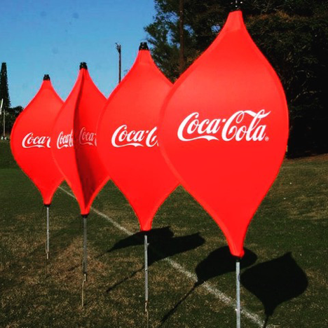 Four large branded lantern pop-out banners in a field with blue sky