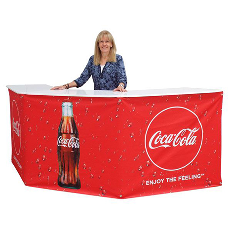 Woman standing behind red branded pop-up counter event table for Coca Cola